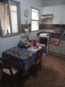 a kitchen with a table with a table cloth on it at Quarto no apartamento do anfitrião na Praia do Canto in Vitória