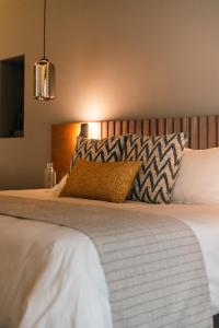 a bedroom with a bed with a pillow on it at Hotel Agua de Plata in San Luis Potosí