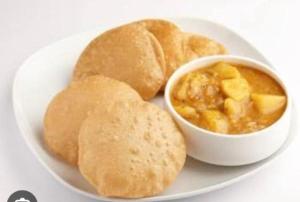 a plate of food with a bowl of soup and bread at HOMESTAY KT palace in Varanasi