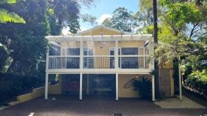 a large house with a screened in porch at Luxury Pearl Beach House with Private Heated Mineral Pool, Yoga Deck & Fire Pit in Pearl Beach