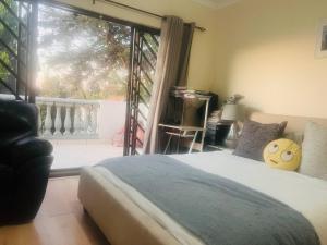 a bedroom with a bed and a large window at 3 bed Cluster home in Sandton in Sandton