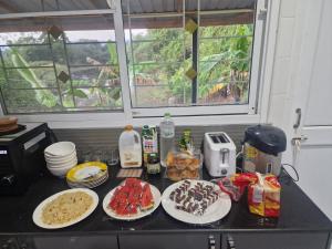 a kitchen counter with plates of food on it at Home Valot Bed and Breakfast in Lan Saka +10 photos