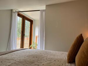 a bedroom with a bed and a large window at Kinsol Hideaway in Shawnigan Lake