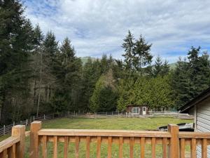 a yard with a wooden fence and a house at Kinsol Hideaway in Shawnigan Lake