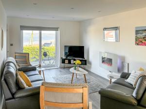 a living room with two couches and a tv at The Holiday House in Benllech