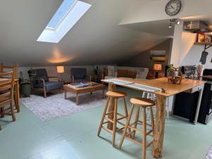 a kitchen and living room with a counter and stools at Kinsol Hideaway in Shawnigan Lake