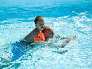a man and a boy in the swimming pool at 4 person holiday home in Allinge in Allinge