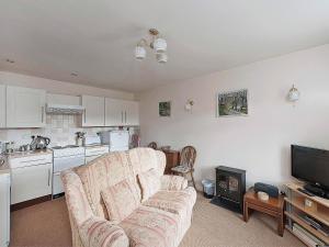 a living room with a couch and a kitchen at Pear Tree Farm Cottages - Rchm38 in Ebberston +2 photos