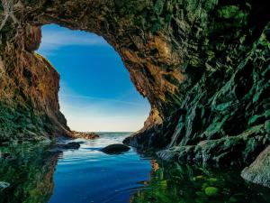 a cave on the beach with the ocean through it at 2 person holiday home in Allinge in Allinge