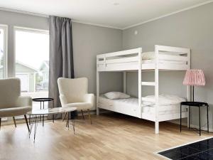 a bedroom with a white bunk bed and chairs at 4 star holiday home in Klintehamn in Klintehamn