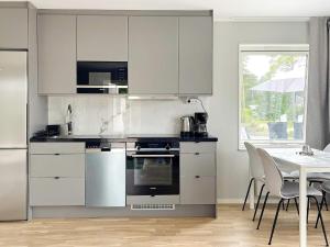 a kitchen with white appliances and a table with chairs at 4 star holiday home in Klintehamn in Klintehamn