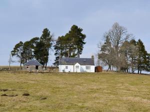 a white house in a field with a barn at Buckhood - Swwy in Inchmill