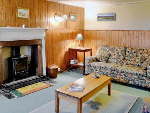 a living room with a couch and a fireplace at Buckhood - Swwy in Inchmill