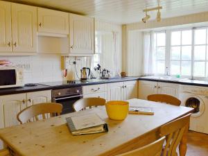 a kitchen with a wooden table with chairs and a tableablish at Buckhood - Swwy in Inchmill +4 photos