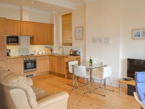 a kitchen with a table and white chairs in a room at Tides Reach in Fowey +9 photos