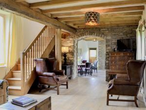 a living room with a staircase and a stone wall at The Old Cider Mill in Llanstephan