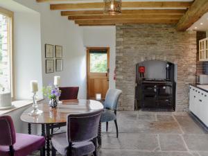 a kitchen and dining room with a table and a fireplace at The Old Cider Mill in Llanstephan