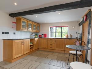 a kitchen with wooden cabinets and a table at Parkers in Mathon +20 photos