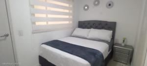 a bedroom with a bed with a blue blanket on it at Room cerca al aeropuerto #5 in Bogotá
