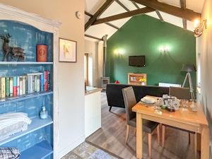a dining room with a table and a book shelf at Nuthatch Barn in Pancrasweek