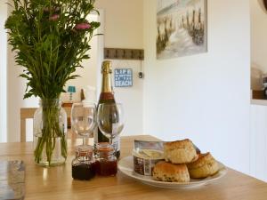 a table with a plate of food and a bottle of wine at Nuthatch Barn in Pancrasweek
