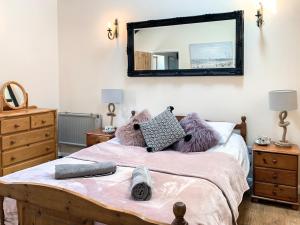 a bedroom with a bed with a mirror on the wall at Nuthatch Barn in Pancrasweek +3 photos