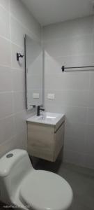 a white bathroom with a toilet and a sink at Room cerca al aeropuerto #5 in Bogotá
