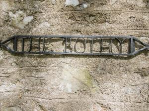 a metal sign on the side of a stone wall at Gardener's Bothy in Balnaboth