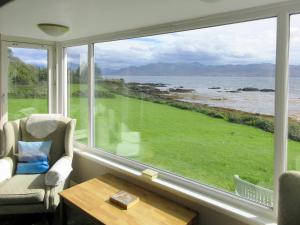 a room with a window with a view of the ocean at Macinnisfree Cottage in Saasaig