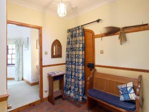 a living room with a bench in a room at Conheath Gatelodge Cottage in Kingholm Quay