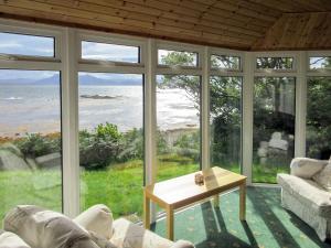 a living room with a view of the ocean at Macinnisfree Cottage in Saasaig