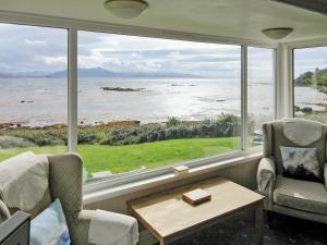 a living room with a view of the ocean at Macinnisfree Cottage in Saasaig