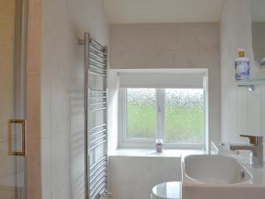 a bathroom with a sink and a window at Bess's Cottage in Middlewich