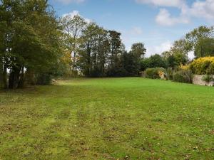 a large field of grass with trees in the background at Fairlaw Garden Cottage in Reston +14 photos