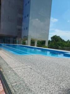a large building with a swimming pool in front of it at Seaview Turtle Cove in Kampong Bugis