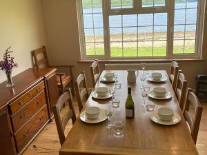 a dining room table with a bottle of wine and glasses at Point Park in Taynuilt +27 photos