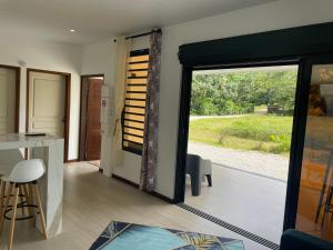 a kitchen with a sliding glass door to a yard at Tycoon Luxury, SPA Privatif, Lit XXL, Cinema in Matoury