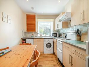 a kitchen with a wooden table and a wooden counter top at Peartree Farm Cottages - Rchm39 in Ebberston