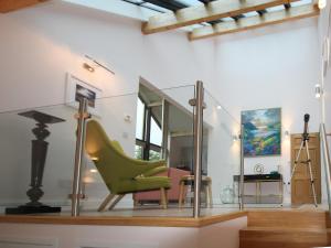 a glass room with a green chair and a lamp at Achabeg - S4597 in Taynish