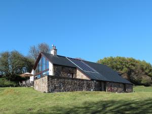 a stone house with a black roof on a hill at Achabeg - S4597 in Taynish