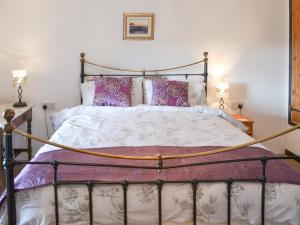a bedroom with a large bed with purple pillows at Purlinney in Treknow