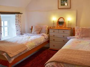 a bedroom with two beds and a dresser with a mirror at Purlinney in Treknow