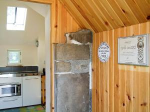 a kitchen with a stone wall in a room at Tullibole Castle Longhouse in Crook of Devon