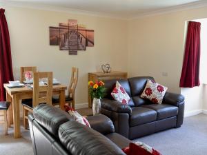 a living room with a leather couch and a table at Flat 2 Lonsdale House in Keswick