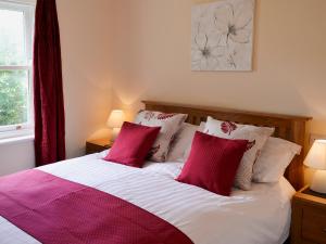 a bedroom with a bed with red and white pillows at Flat 2 Lonsdale House in Keswick