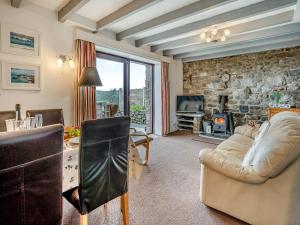 a living room with a stone wall at Granary Cottage - Uk10695 in Amroth