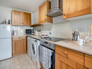 a kitchen with a washer and dryer at Granary Cottage - Uk10695 in Amroth +17 photos