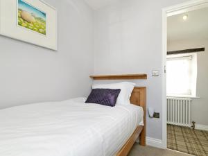a bedroom with a white bed and a window at Pinfold Cottage in Richmond +9 photos