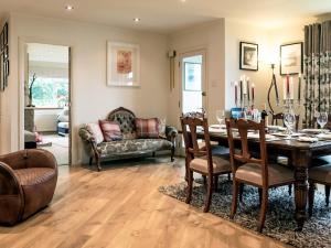 a dining room with a table and a couch at Tigh-Na-Creige in Feorlean