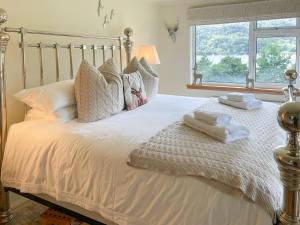 a bedroom with a bed with two towels on it at Tigh-Na-Creige in Feorlean +25 photos